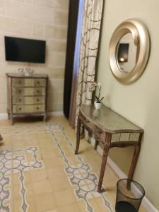 a living room with a table and a mirror at Charming Town House Suite - Close to Airport in Paola