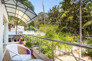 - un balcon avec une table, des chaises et des arbres dans l'établissement Amara Baga Villa 5BHK, à Baga