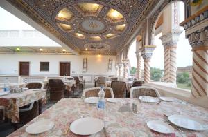 comedor con mesas y sillas y techo en Hotel Heritage Mandawa, en Mandāwa