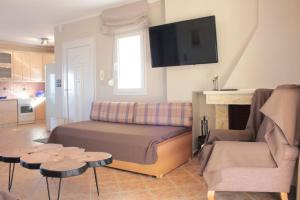 a living room with a couch and a tv on the wall at Apartment Achilles in Litochoro