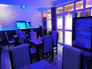 comedor con mesa e iluminación azul en Presken Hotels @ Freedom Way, Lekki, en Lekki