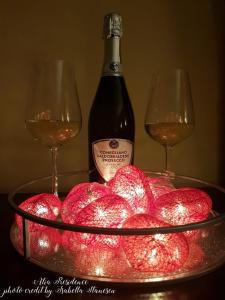 two glasses of wine next to a bowl of apples at Atia Residence in Sibiu +16 photos