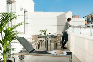 a man standing on the balcony of a building at Eric Vökel Boutique Apartments - Atocha Suites in Madrid