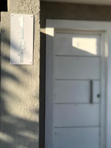 una puerta de garaje blanca con un número ocho en ella en Departamentos Alberdi 3 en San Rafael