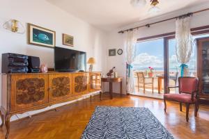 uma sala de estar com televisão e uma grande janela em Apartments Sunrise em Split