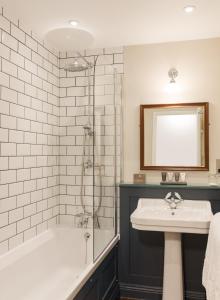 a bathroom with a tub and a sink and a shower at Burley Manor in Burley