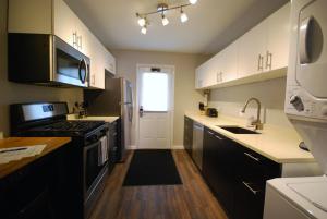 uma cozinha com armários brancos e um forno com placa de fogão em Brookwood Courtyard by BCA Furnished Apartments em Atlanta