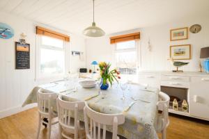 a kitchen with a dining room table and chairs at Shore Cote, Thorpeness in Thorpeness