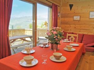 a table with a red table cloth and flowers on it at Modern chalet just 350 m from the ski lifts in Peisey-Nancroix