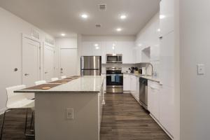 a kitchen with white cabinets and a counter top at Spectacular Suites by BCA Furnished Apartments in Atlanta