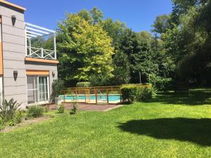 a house with a swimming pool in a yard at La Naturaleza de Parque Leloir en Familia in Villa Leloir