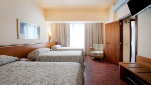 a hotel room with a bed and two nightstands at BULL Astoria in Las Palmas de Gran Canaria