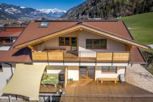 a house with a wrap around deck with mountains in the background at Ferienhaus Höllwarth in Stumm