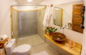 a bathroom with a shower and a sink and a toilet at Pousada Chez Toi in Jericoacoara