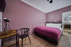 - une chambre avec un lit, un bureau et une horloge dans l'établissement Salzburg Topside Apartment, à Salzbourg