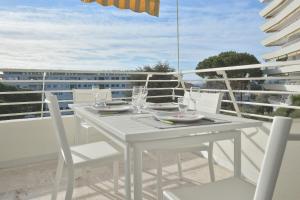 un tavolo bianco e sedie sul balcone di Cannes Hillside With terrace and swimming pool a Cannes