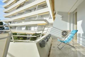 una sedia blu su un balcone con un edificio di Cannes Hillside With terrace and swimming pool a Cannes