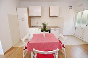 a kitchen with a table with a red table cloth at Apartments Nodilo in Polače