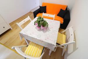 a table and two chairs and a table with a plant on it at Apartments Nodilo in Polače