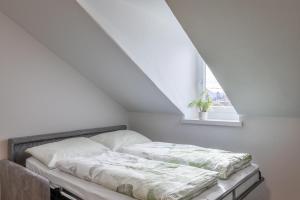 uma cama num quarto branco com uma janela em Apartment Villa Schmid em Bolzano