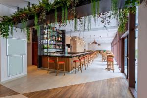 a bar in a restaurant with chairs and plants at TRYP by Wyndham Sao Paulo Paulista Paraiso in São Paulo