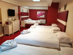 um quarto de hotel com quatro camas e uma televisão em Sutherlands Hotel em Gateshead
