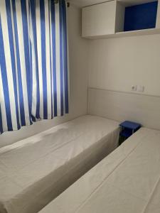 two beds in a room with a striped curtain at Villa Granja Sol in São Félix da Marinha