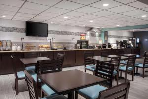 a restaurant with tables and chairs and a counter at La Quinta Inn by Wyndham Cocoa Beach-Port Canaveral in Cocoa Beach