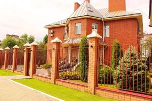 a fence in front of a red brick house at Парк Отель Заречный in Balakovo