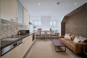eine Küche und ein Wohnzimmer mit einem Sofa und einem Tisch in der Unterkunft Residence Mozart by Welcome to Salzburg in Salzburg