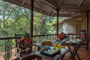 a porch with a chess board on a table at SaffronStays Parsi Manor - 4-BR heritage villa near Charlotte Lake serving authentic Parsi meals in Matheran