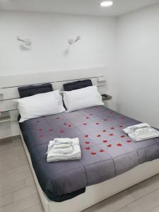 una camera da letto con un letto con cuori rossi sopra di Casetta fiori di loto a Palermo