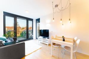 sala de estar con mesa y TV en Apartment Monochrome Urban Hoodie, en Liubliana