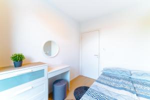 sypialnia z łóżkiem, komodą i lustrem w obiekcie Apartment Monochrome Urban Hoodie w Lublanie