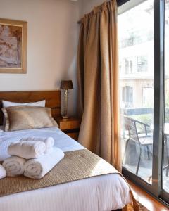 a bedroom with a bed with towels on it at Lycabettus Exclusive Apartments in Athens