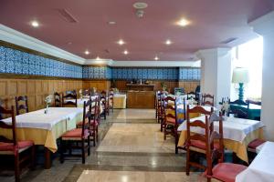 a restaurant with tables and chairs and a kitchen at Hotel Apartamentos Trevenque in Sierra Nevada