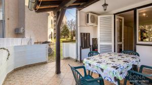 eine Terrasse mit einem Tisch und Stühlen auf dem Balkon in der Unterkunft Rona Apartment Porat 2 in Poreč