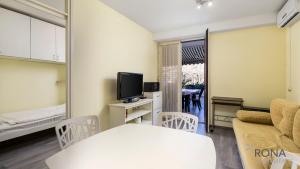 a small living room with a couch and a tv at Rona Apartment Porat in Poreč