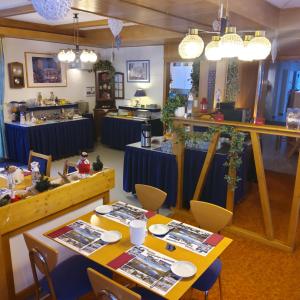 格雷興的住宿－阿爾法酒店，一间用餐室,配有两张桌子和椅子以及蓝桌布