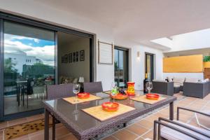 a dining room with a table and chairs and a glass door at Alamar Poolfront garden apartment Ref 46 in Mijas Costa