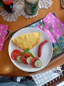 a plate of food with eggs and vegetables on a table at Knysna Paradise Guesthouse in Knysna
