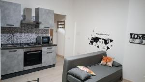 a living room with a couch and a kitchen at Giordiehouse 1 Restyling in Latina
