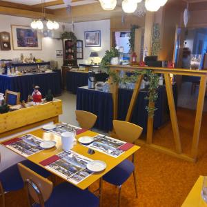 a dining room with two tables with blue table cloth at Hotel Alpha in Grächen