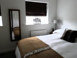 a bedroom with a bed and a mirror and a window at Demesnes View in Barnard Castle