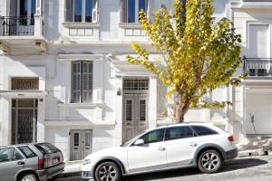 a white car parked in front of a white building at Acropolis Memories in Athens