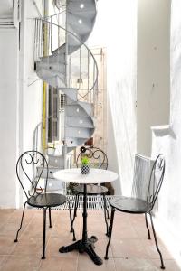 una mesa y sillas en una habitación con escalera en Acropolis Memories en Athens