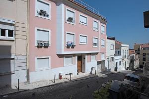 a pink building on a street with a parking lot at Graça 4 in Lisbon