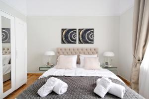 um quarto branco com uma cama grande e 2 almofadas em Acropolis Memories em Atenas