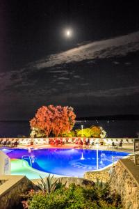 a large swimming pool at night with a full moon at Hotel Dražica - Hotel Resort Dražica in Krk