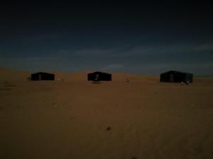 Un groupe de huttes au milieu du désert dans l'établissement Bivouac L'Erg, à M'Hamid El Ghizlane